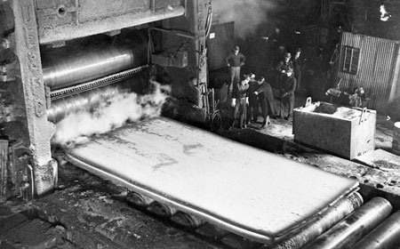 A finished plate exits the 206” mill. — Hagley Museum & Library