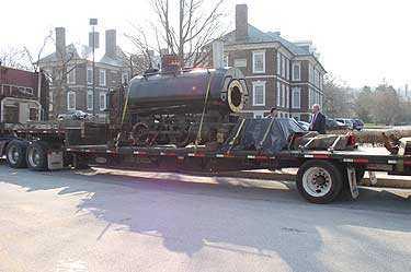 The Engine arriving at the office, all the parts are under tarps. Roof, cab, sand, domes, etc. Charles Lukens Huston III is talking to the truck driver.