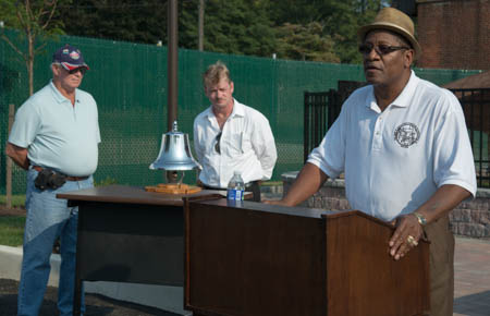 John Washington reads names listed on the monument.
